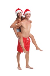 Photo of Happy couple with Santa hats together on white background. Christmas vacation