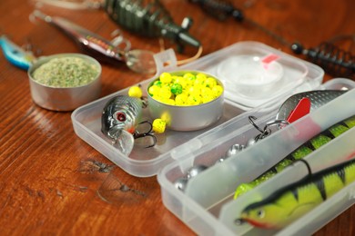 Photo of Fishing tackle. Different baits and lures on wooden table, closeup