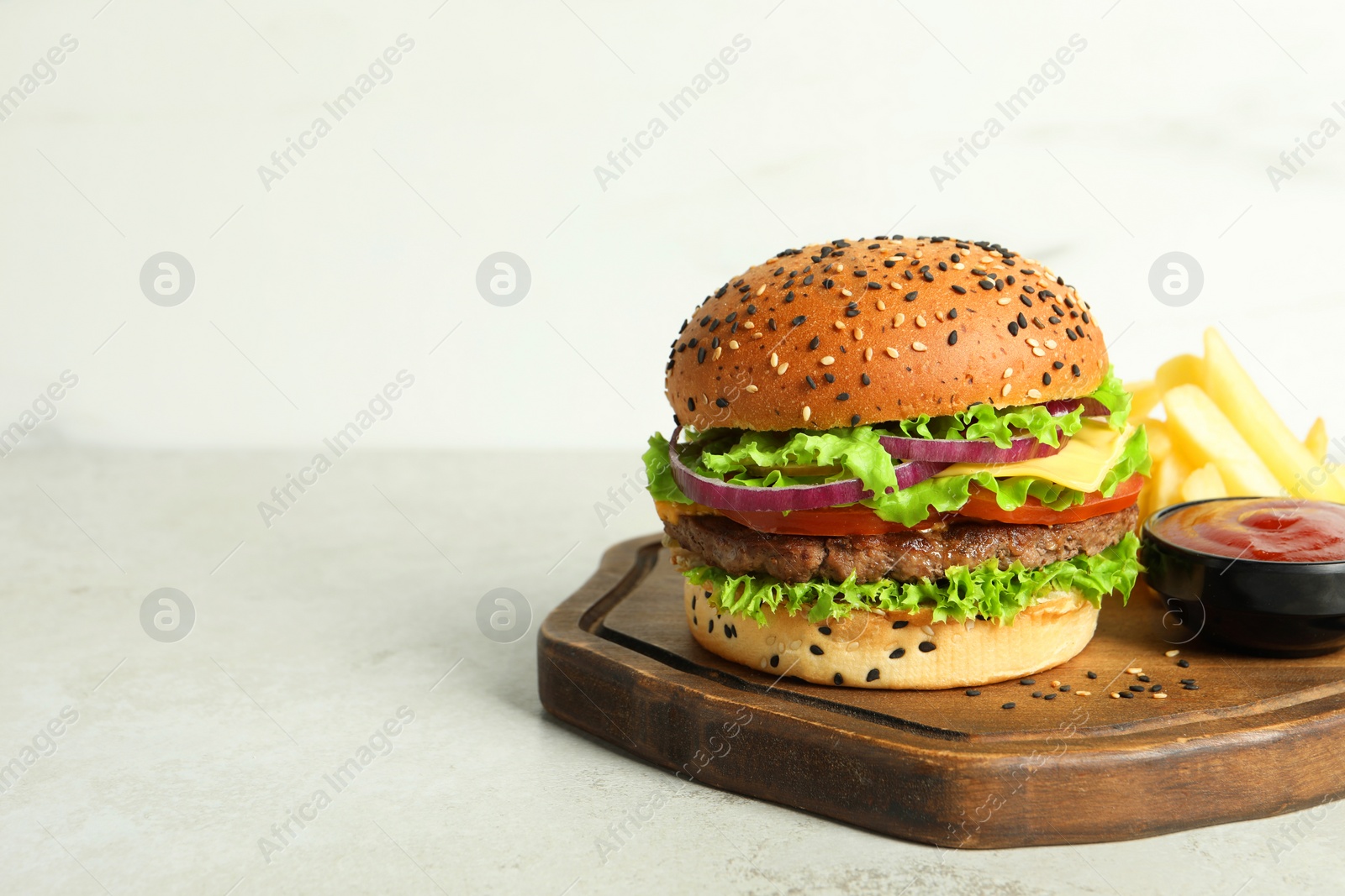 Burger with delicious patty, french fries and sauce on light table, space for text Photo of Burger with delicious patty, french fries and sauce on light table, space for text