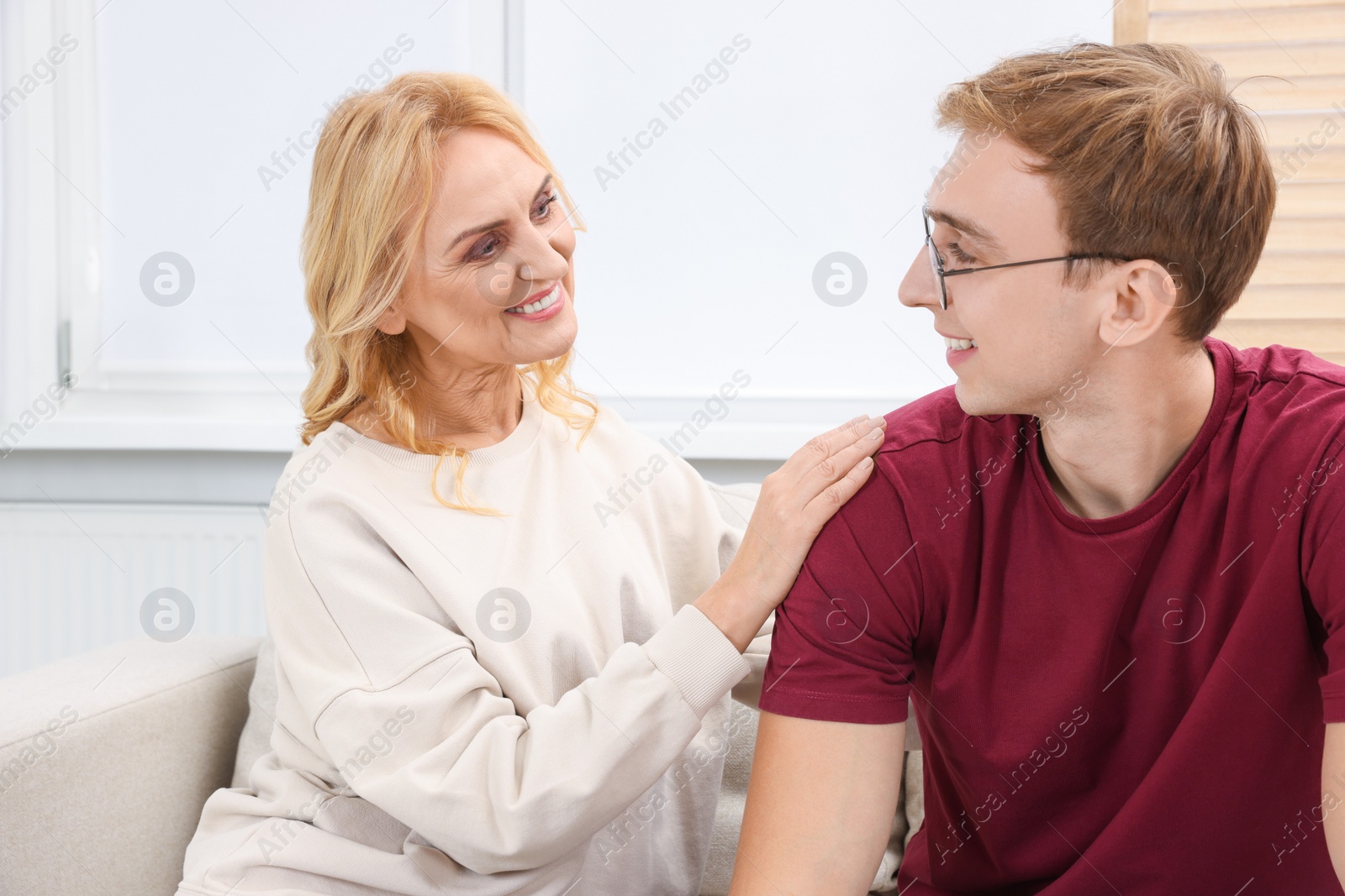 Photo of Mother and son spending time together on sofa at home. Family bonding