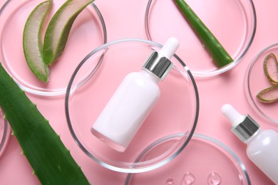 Flat lay composition with aloe vera leaves and cosmetic products on pink background