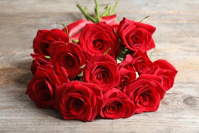 Photo of Beautiful red rose flowers on wooden background