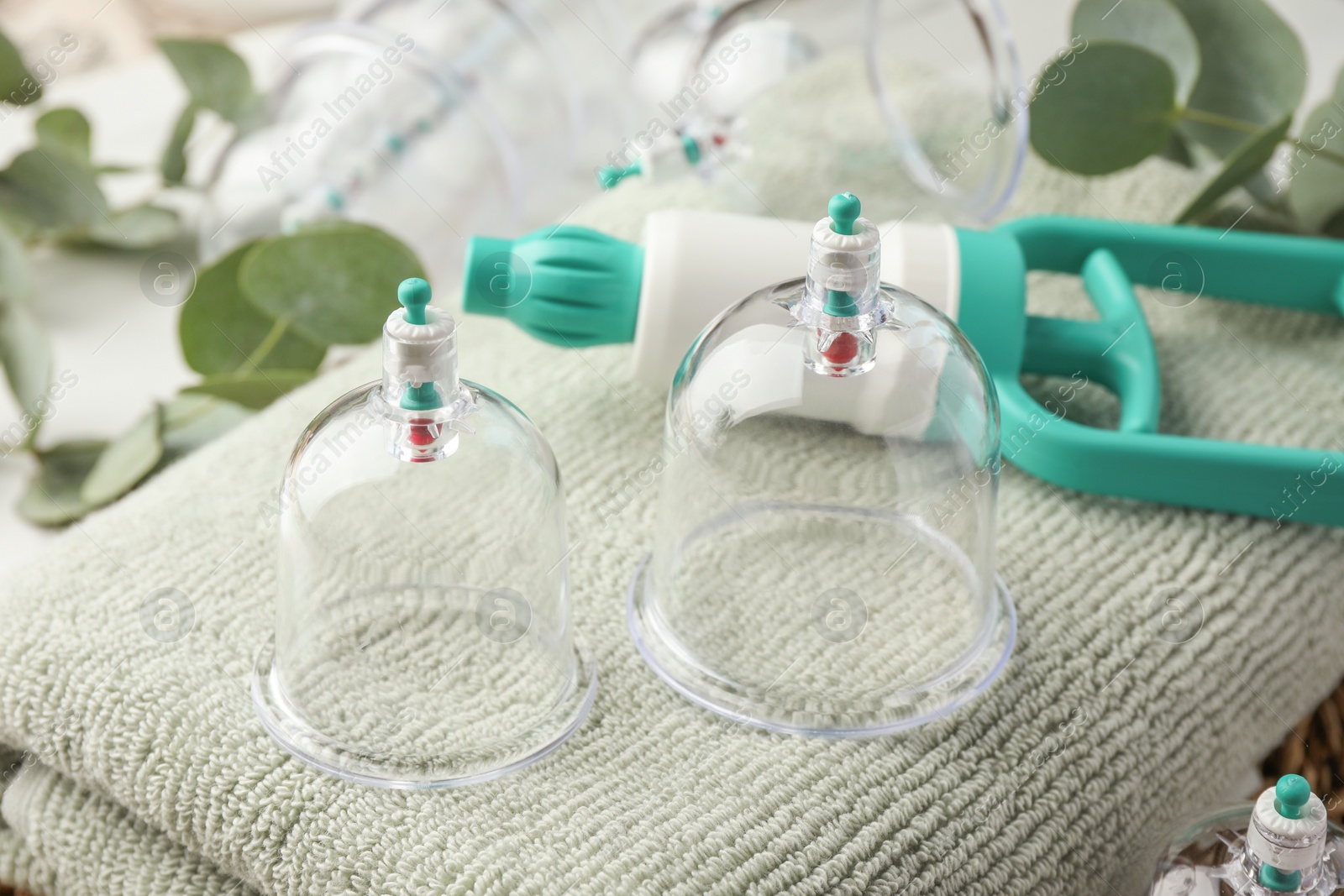 Photo of Cupping therapy. Plastic cups and hand pump on soft towel, closeup