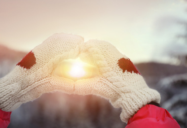 Woman with warm mittens outdoors, closeup. Winter vacation