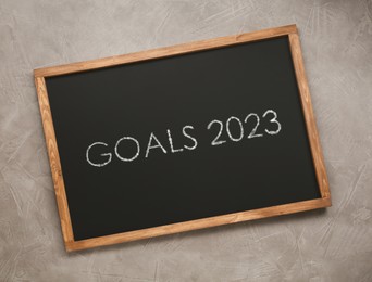 Image of Blackboard with phrase GOALS 2023 on light grey stone background, top view