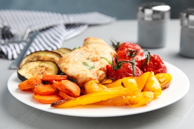 Delicious cooked chicken and vegetables on grey table, closeup. Healthy meals from air fryer