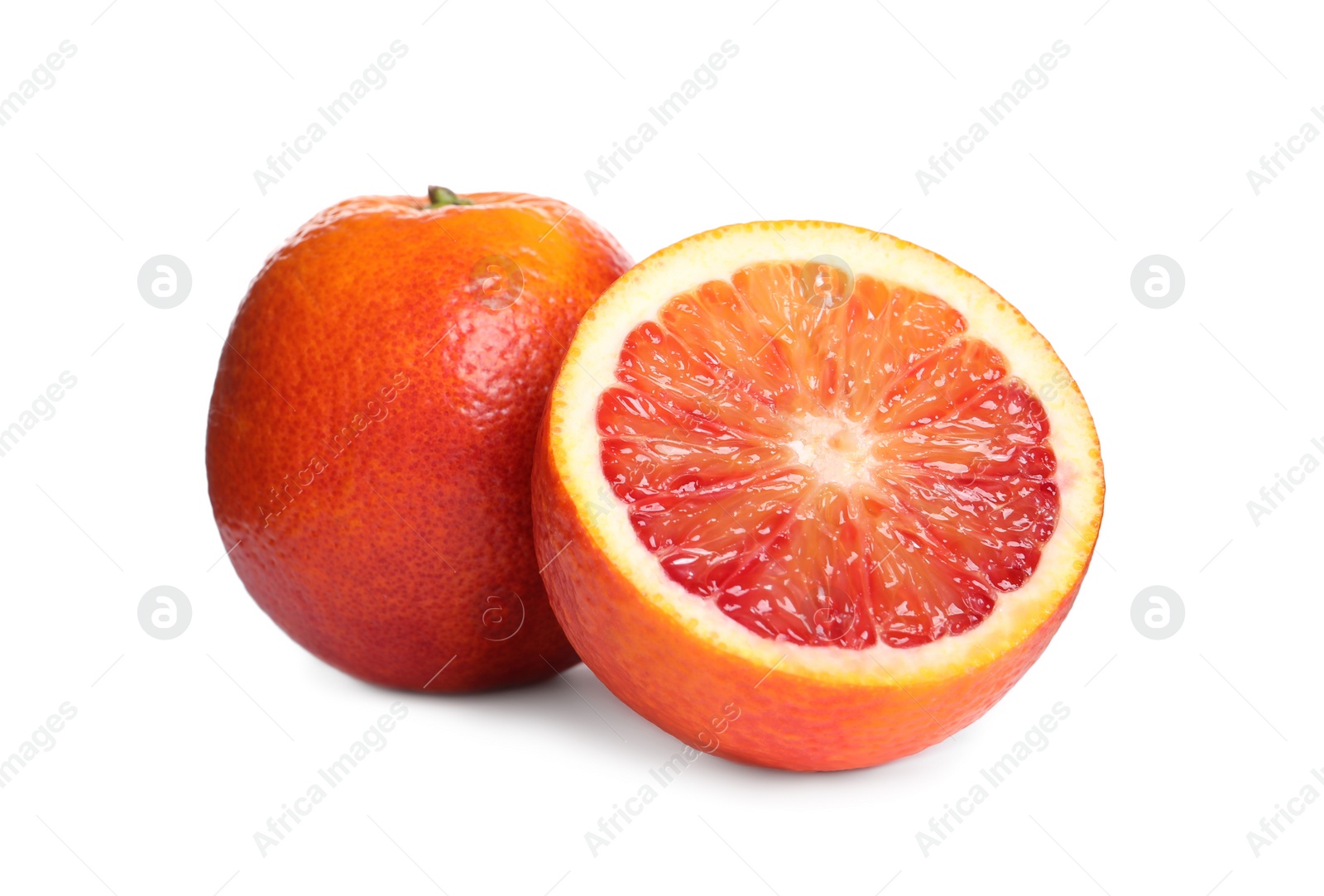 Photo of Whole and cut red oranges on white background