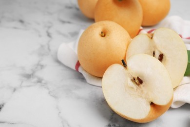 Photo of Delicious apple pears on white marble table, closeup. Space for text