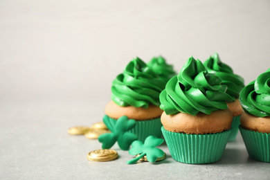 Decorated cupcakes and coins on grey table. St. Patrick's Day celebration