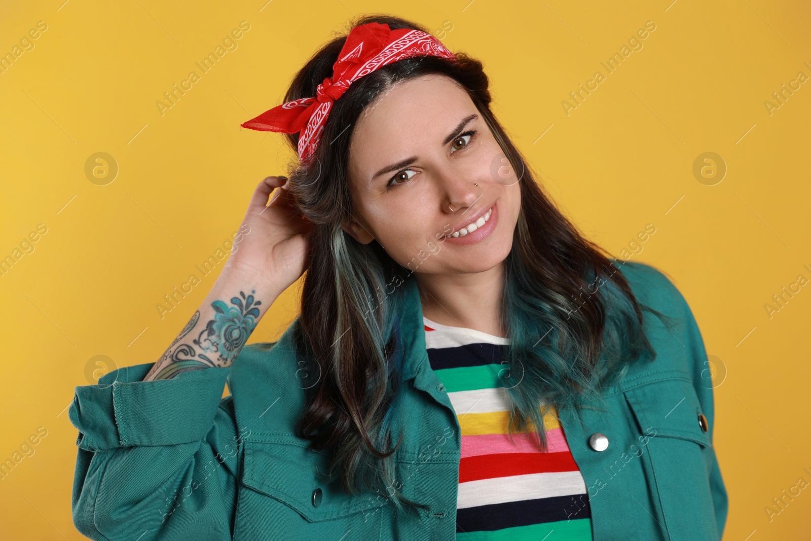 Photo of Beautiful young woman with nose piercing on yellow background