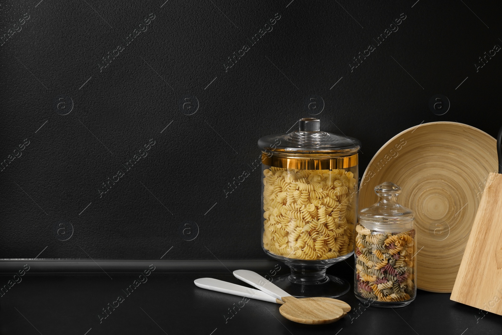 Photo of Products and modern kitchen utensils on black table. Space for text