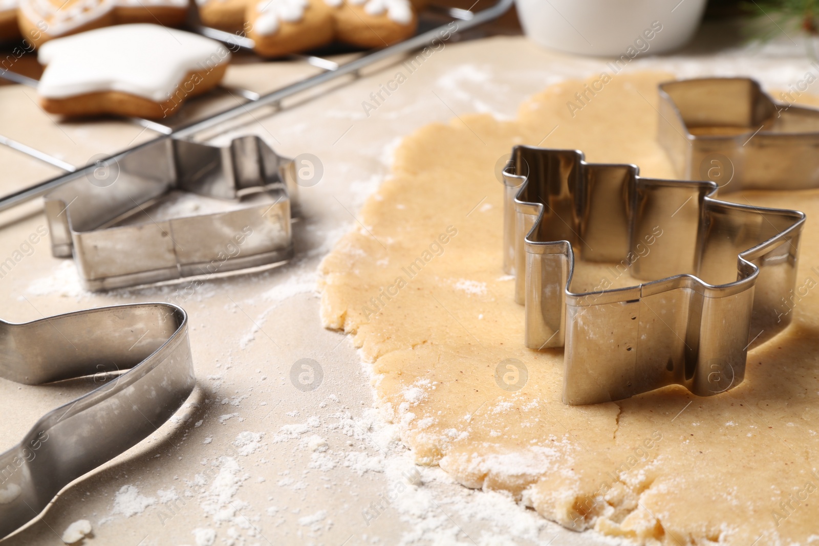 Photo of Making Christmas cookies. Raw dough and different metal cutters on table, closeup