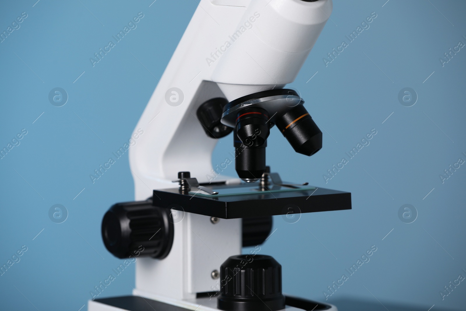 Photo of Modern microscope on blue background, closeup. Medical equipment