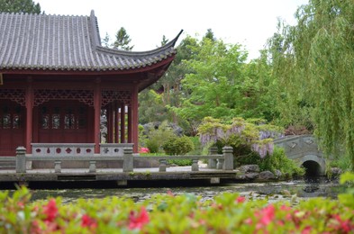 HAREN, NETHERLANDS - MAY 23, 2022: Beautiful view of oriental building near pond in Chinese garden