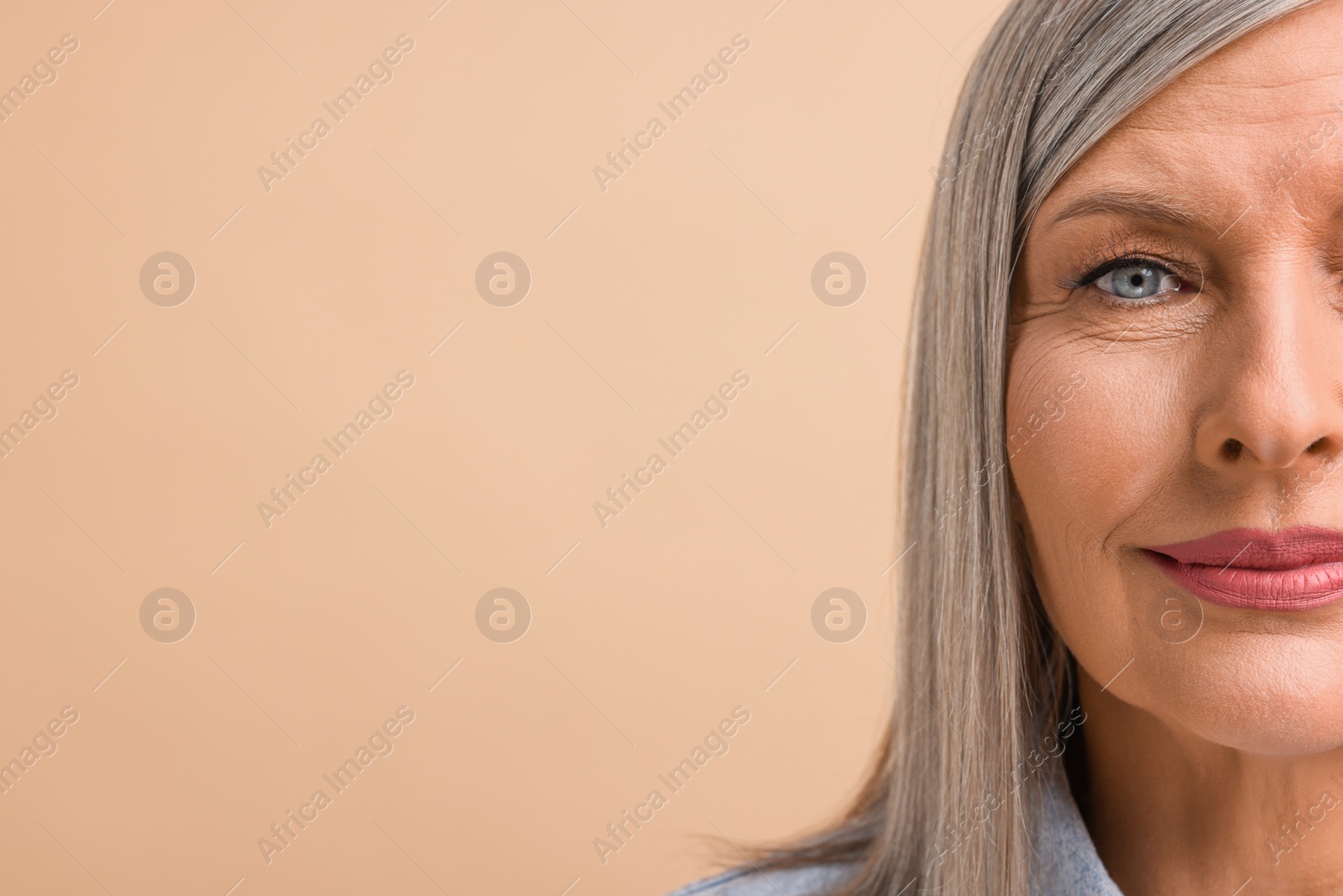 Photo of Portrait of beautiful middle aged woman on beige background, closeup. Space for text