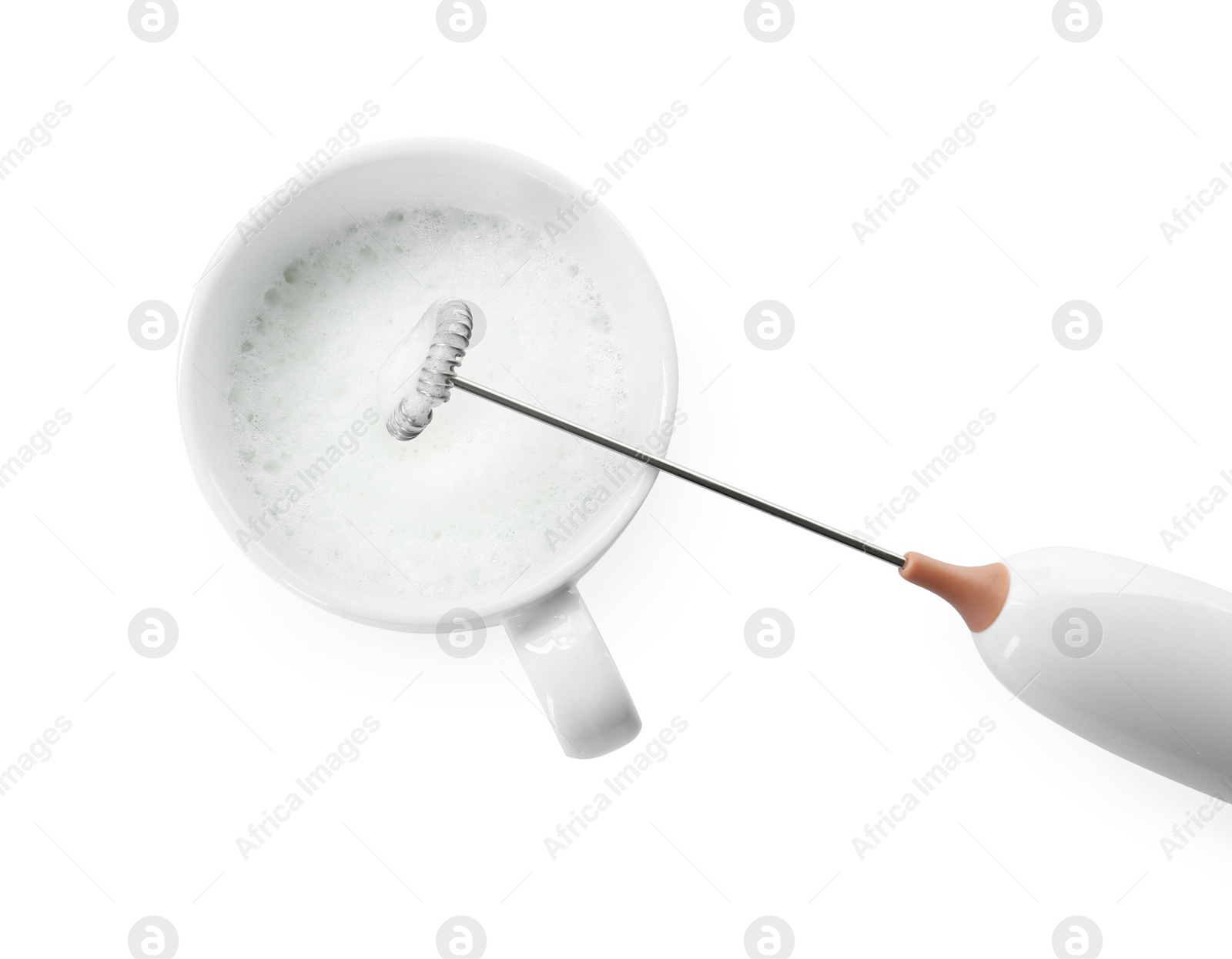 Photo of Whisking milk in cup with mini mixer (frother wand) isolated on white, top view