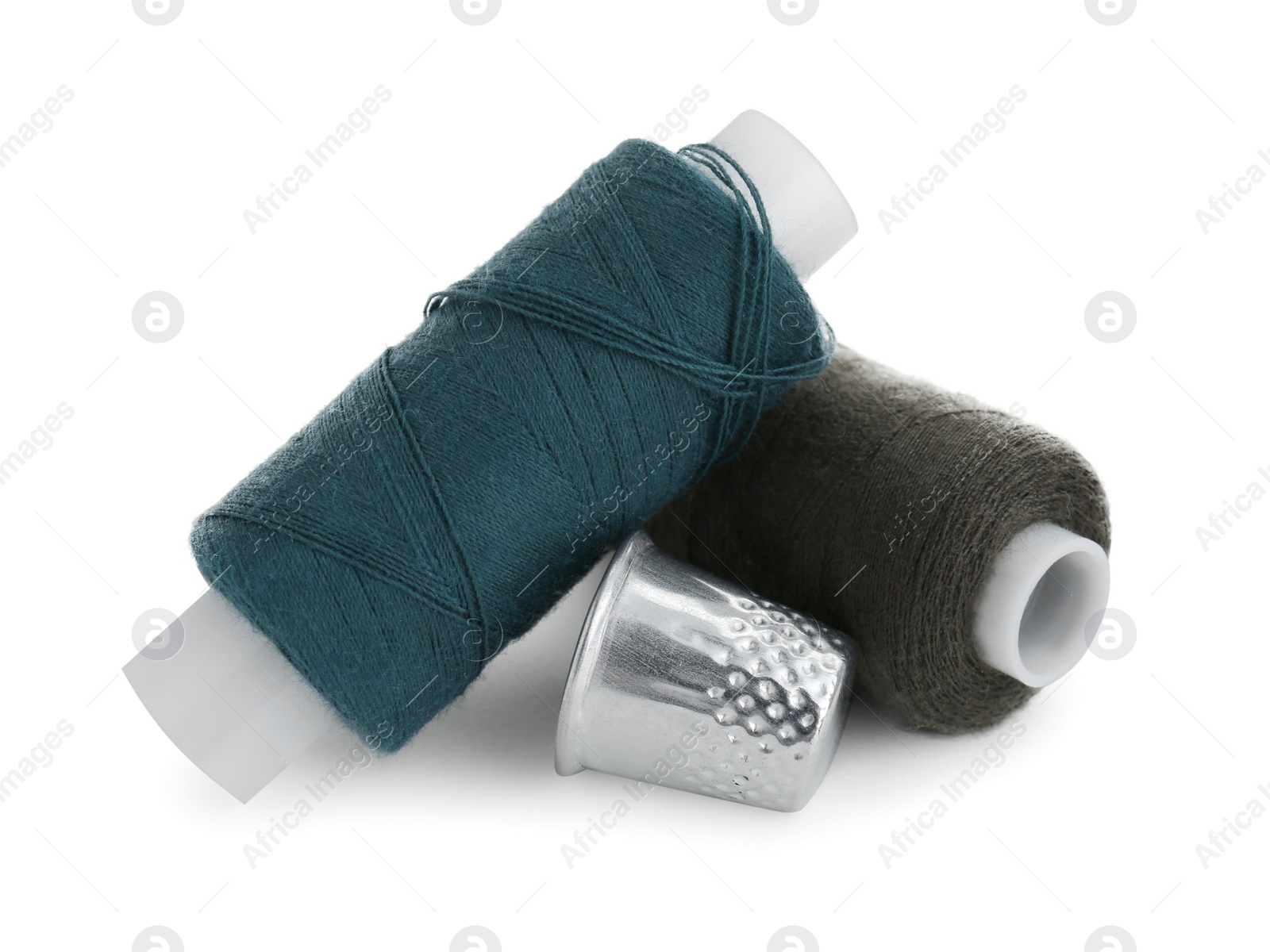 Photo of Thimble and spools of sewing threads isolated on white