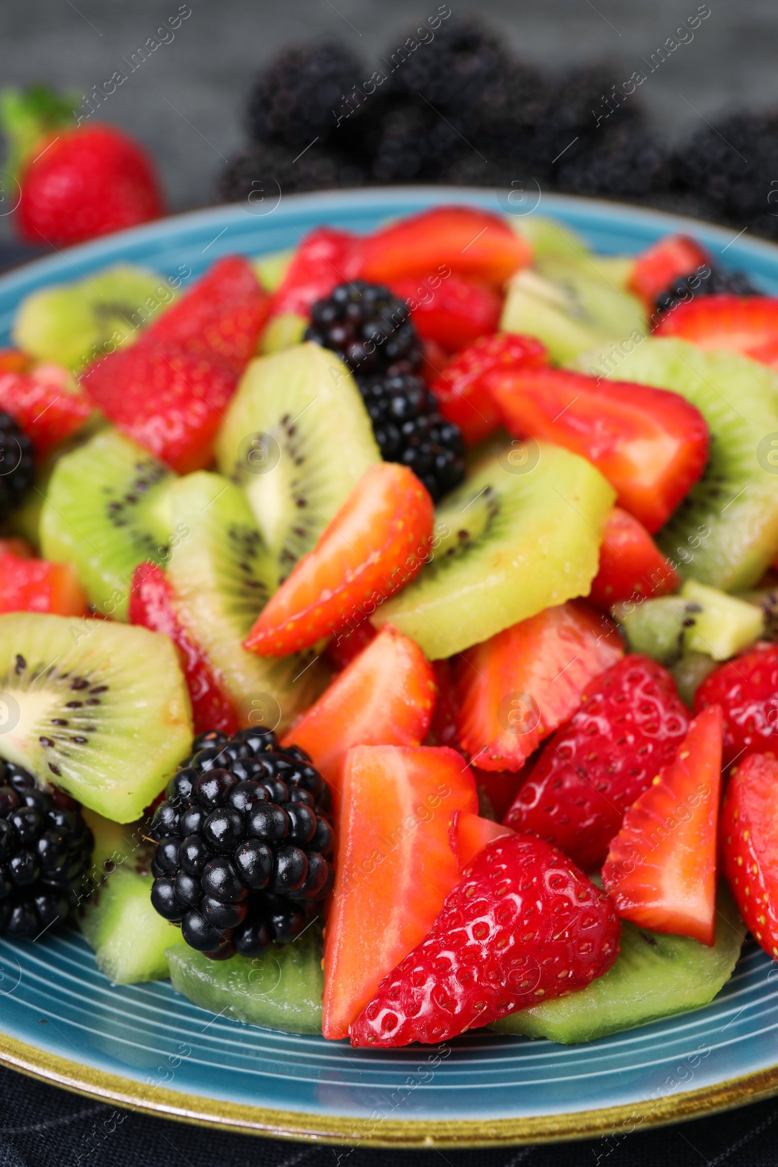 Photo of Plate of delicious fresh fruit salad on table, closeup