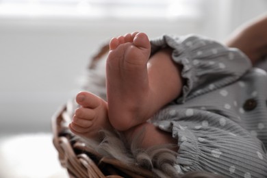 Photo of Adorable newborn baby in wicker basket with faux fur, closeup