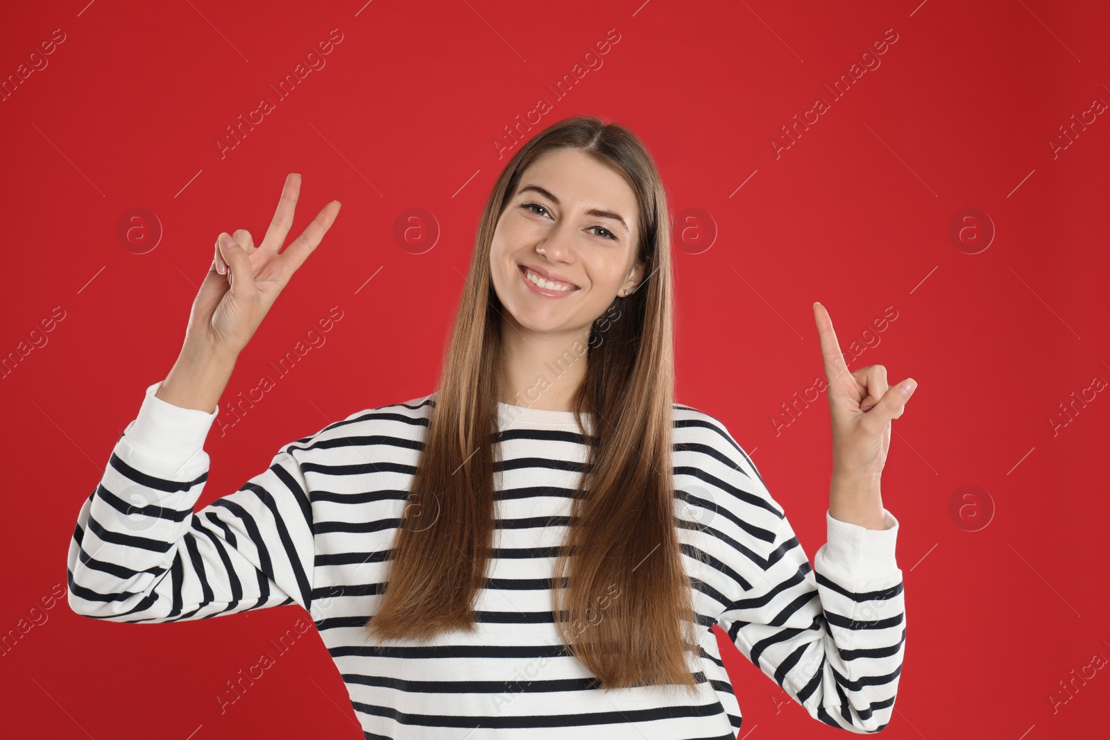 Photo of Woman showing number three with her hands on red background