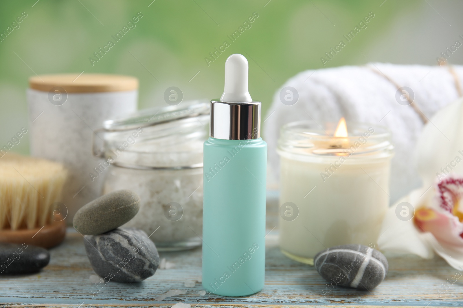 Photo of Composition with spa cosmetic and orchid flower on light wooden table, closeup