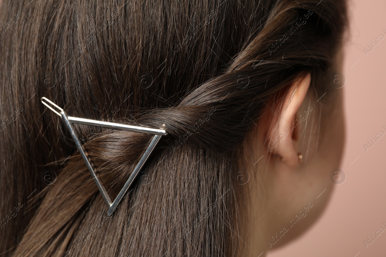 Photo of Young woman with beautiful hair clip on pink background, closeup