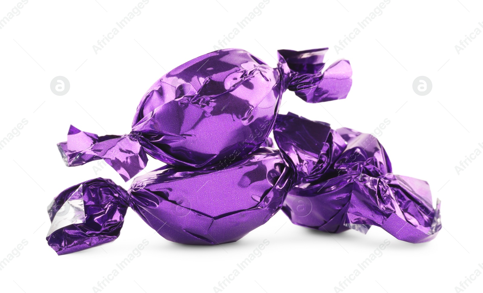 Photo of Candies in purple wrappers isolated on white