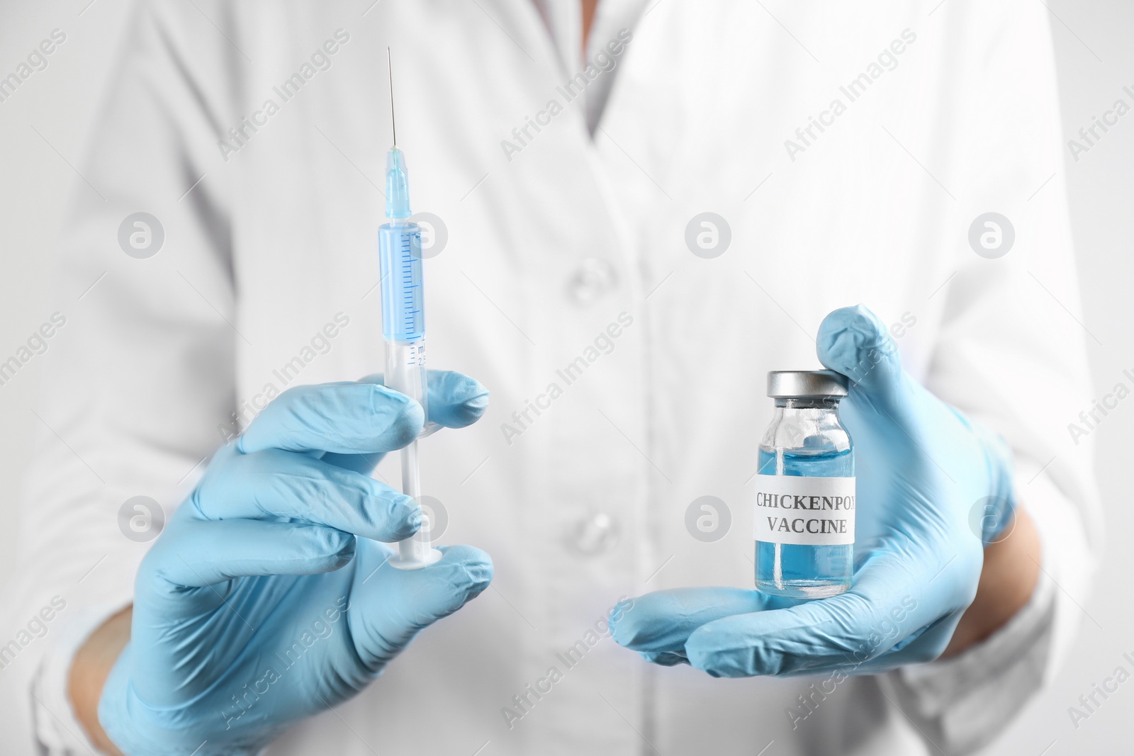 Photo of Doctor holding chickenpox vaccine and syringe, closeup. Varicella virus prevention