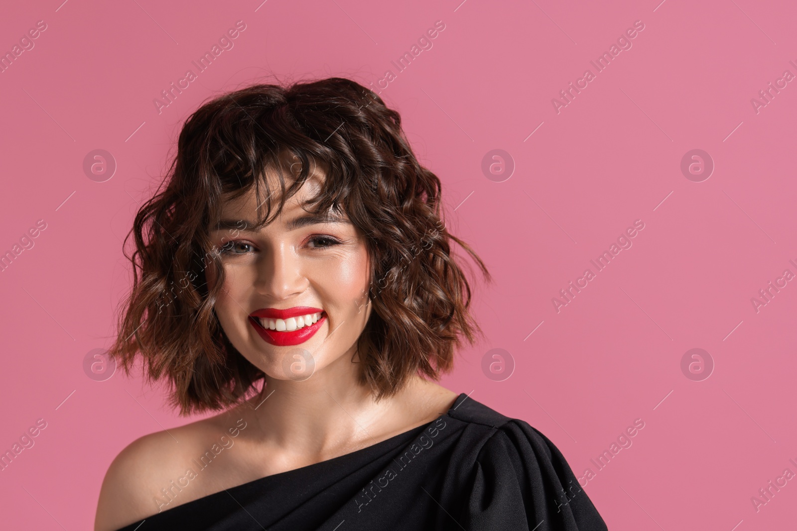 Photo of Portrait of beautiful young woman with wavy hairstyle on pink background. Space for text