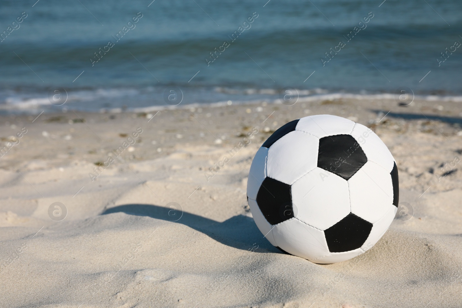 Photo of Soccer ball on beach, space for text. Football equipment