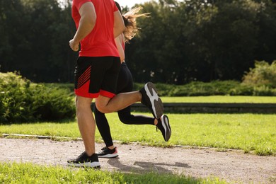 Photo of Healthy lifestyle. Couple running in park on sunny day, closeup