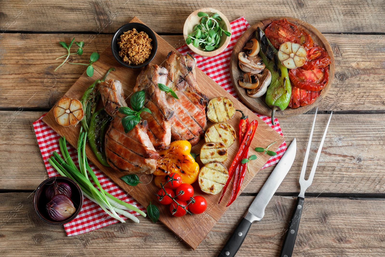 Photo of Delicious grilled meat and vegetables served on wooden table, flat lay