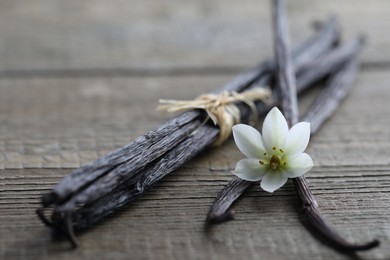 Vanilla pods and flower on wooden table, closeup