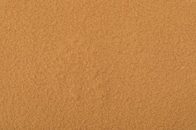 Dry aromatic cinnamon powder as background, top view