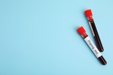 Test tubes with blood samples on light blue background, flat lay and space for text. Doping control