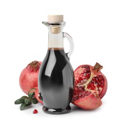 Photo of Tasty pomegranate sauce in bottle, fruits and branch isolated on white