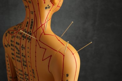 Photo of Acupuncture - alternative medicine. Human model with needles in shoulder near dark grey background