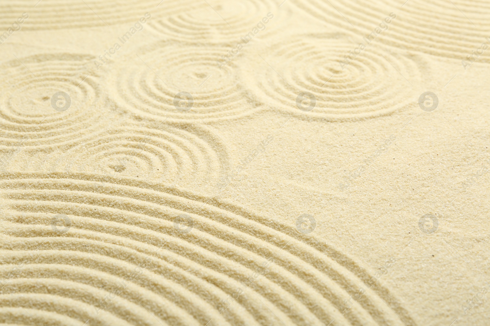 Photo of Zen rock garden. Circle pattern on beige sand