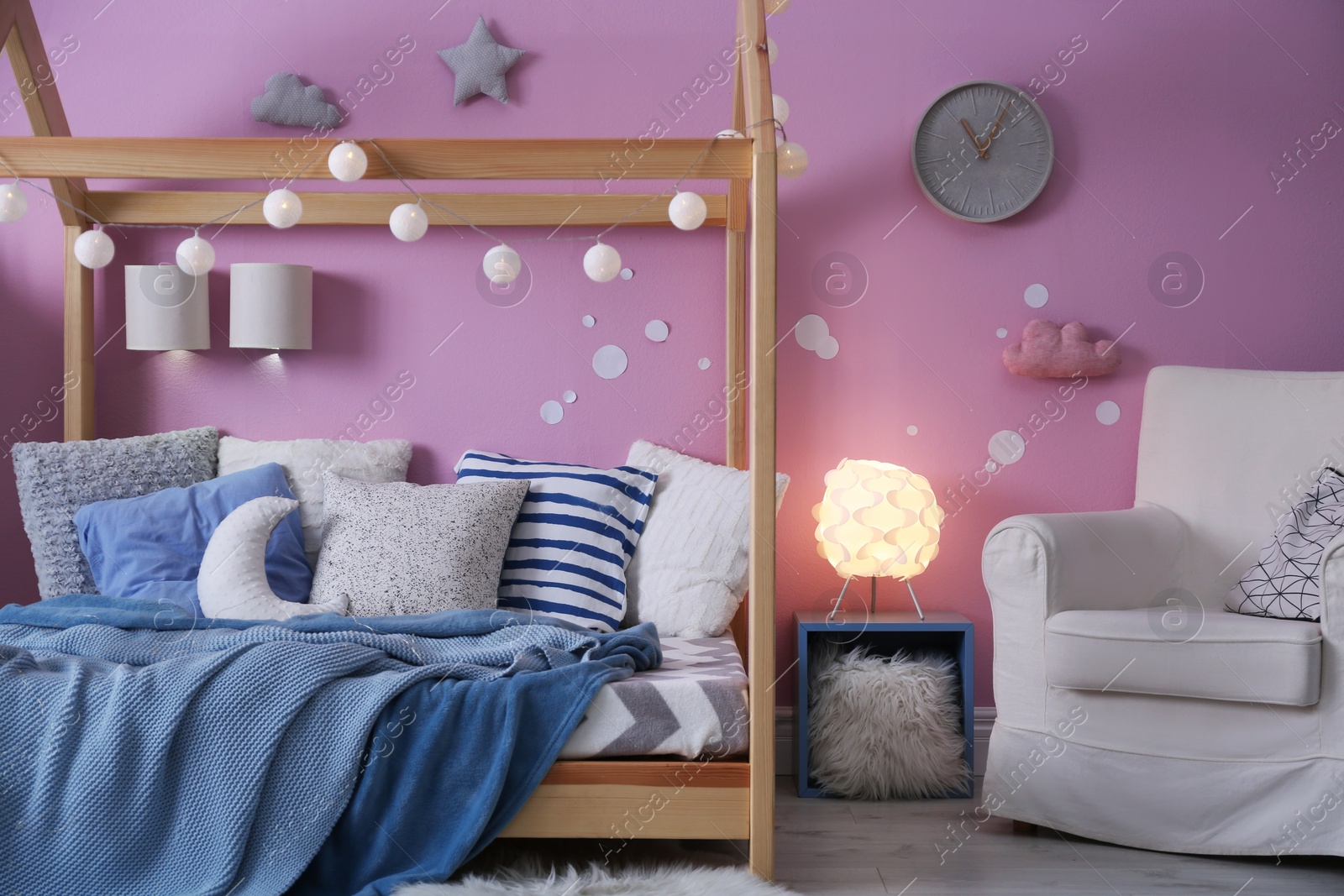 Photo of Child's room interior with comfortable bed and garland