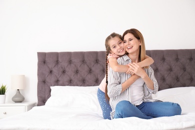 Mother with cute child in bedroom. Happy family