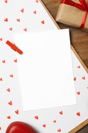 Photo of Flat lay composition with blank card on wooden background, space for text. Valentine's Day celebration