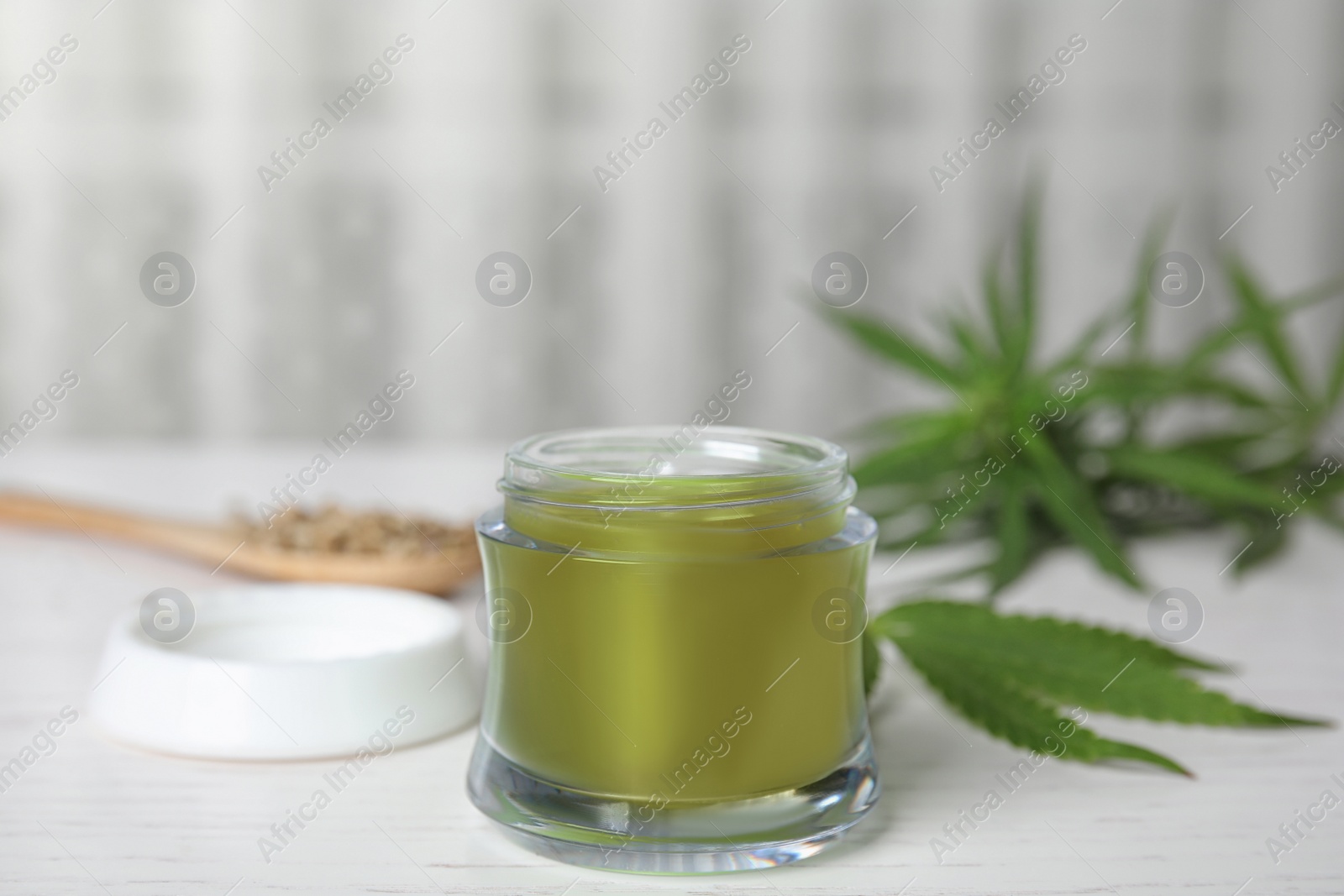 Photo of Jar of hemp cream on white wooden table. Organic cosmetics