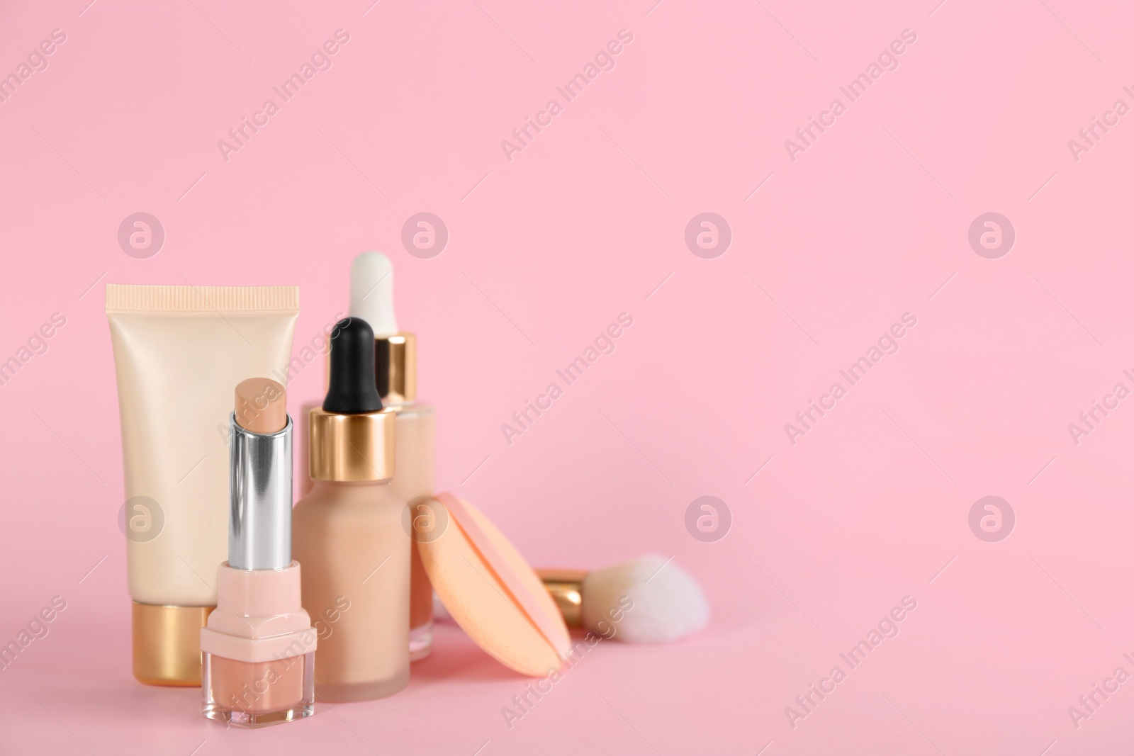 Photo of Foundation makeup products on pink background, space for text. Decorative cosmetics