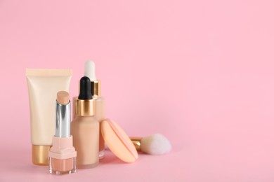 Photo of Foundation makeup products on pink background, space for text. Decorative cosmetics