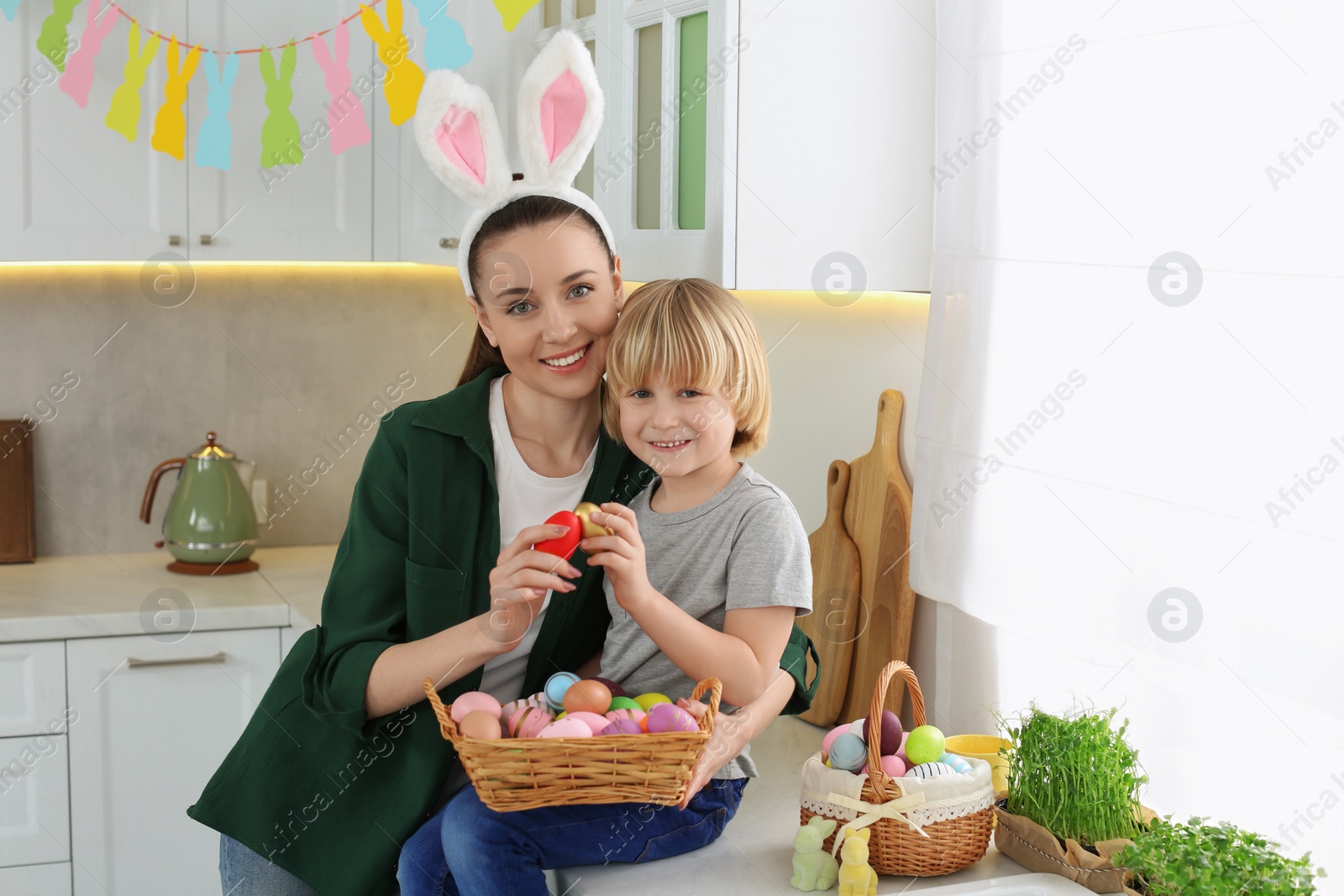 Photo of Mother and her son with Easter eggs in kitchen