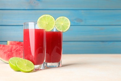 Tasty summer watermelon drink with lime in glasses on table against light blue background. Space for text