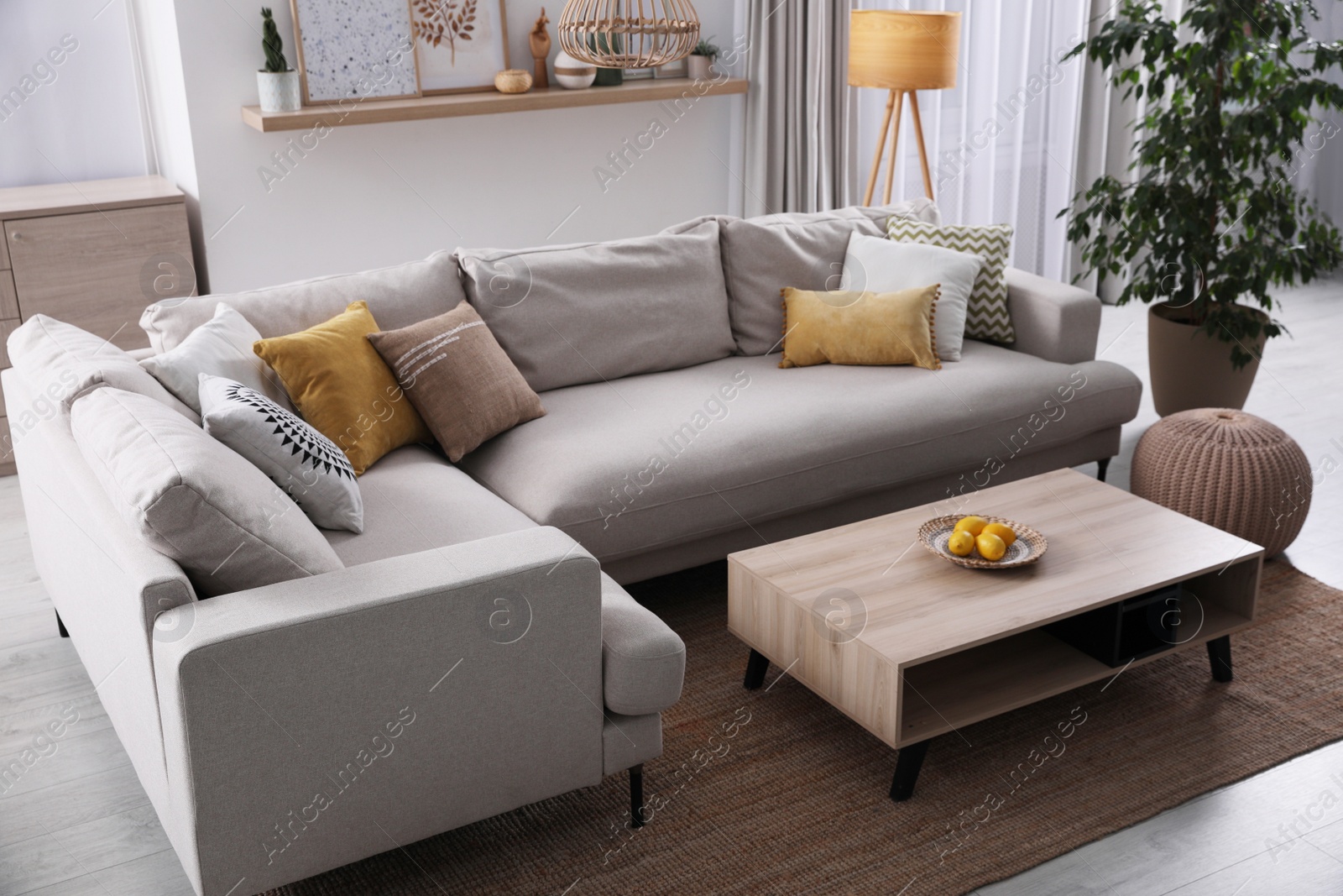 Photo of Stylish living room interior with comfortable grey sofa and coffee table