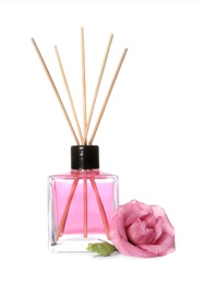 Aromatic reed air freshener and rose on white background