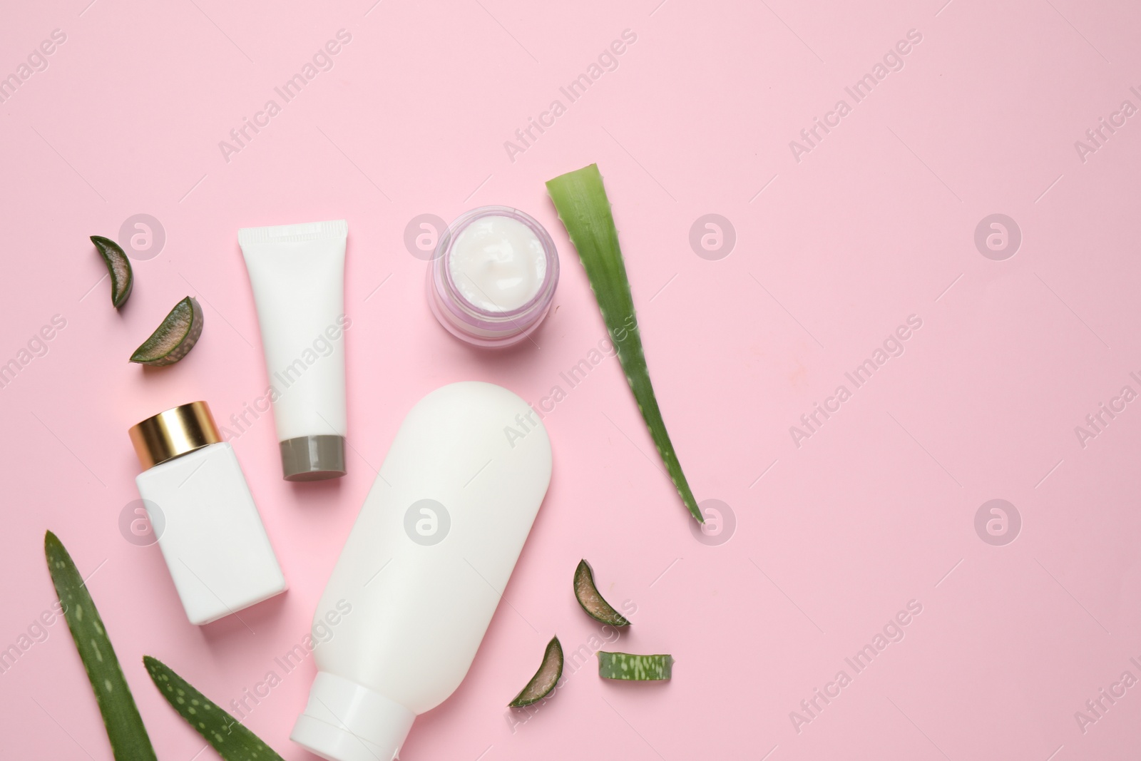 Photo of Flat lay composition with aloe vera and cosmetic products on pink background. Space for text