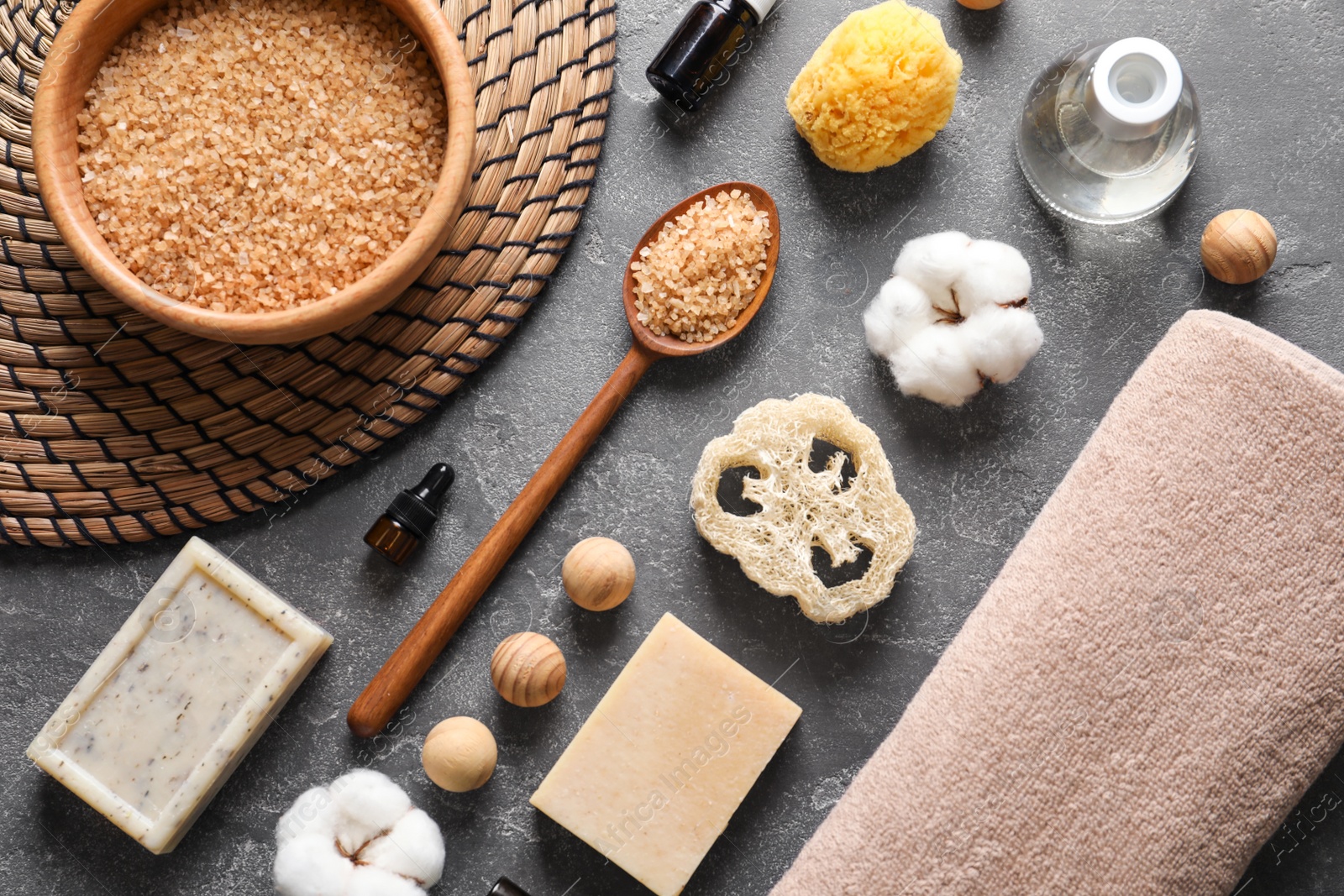 Photo of Flat lay composition with spa cosmetics and towel on grey background